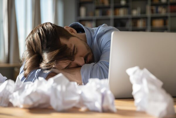 Exhausted writer sleeping beside unfinished manuscript