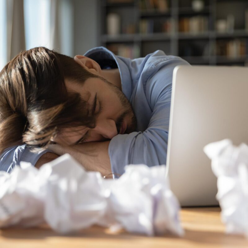 Exhausted writer sleeping beside unfinished manuscript